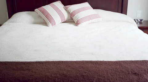Tilt up of a large bed in a bedroom Stock Footage 43671098