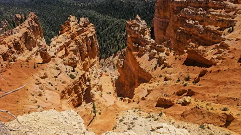 Tilt-Looking down-brilliant orange rock formations-distant valley Stock Footage 247332761