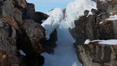 Tilt up low angle of frozen Bruarfoss, whirlpool between basaltic rocks Stock Footage 332495277