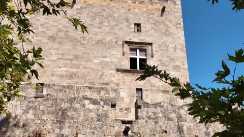 Tilt Up of Medieval Castle Tower Framed by Tree Leaves, Rhodes Stock Footage 340575961