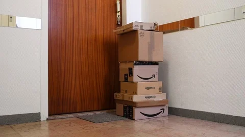Tilt-up Multiple Amazon Prime cardboard parcels near apartment door 스톡 동영상 100823387