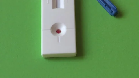 Tilt up of negative COVID-19 IgM/IgG Ab blood test on green background Stock Footage 132364081