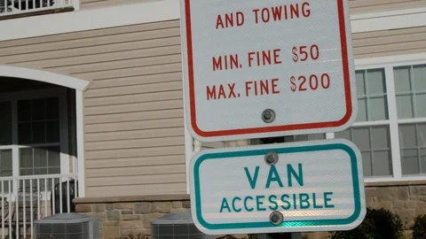 Tilt up on parking signs including violators and reserved parking 動画素材 100724432
