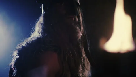 Tilt-up portrait of Thor with a torch hanging in the background - Reenactment Stock Footage 202898227