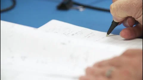 A Tilt up with rack focus to hands writing Video stock 155534123
