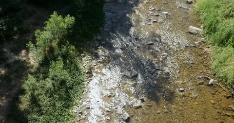 Tilt up of a river flowing away from the camera during the day next to houses Stock Footage 87777073