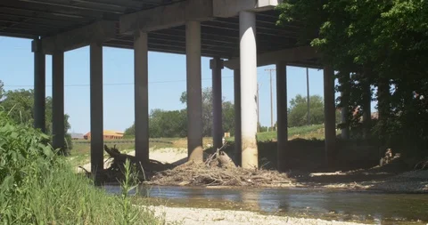 Tilt of river underneath overpass Stock Footage 89777236