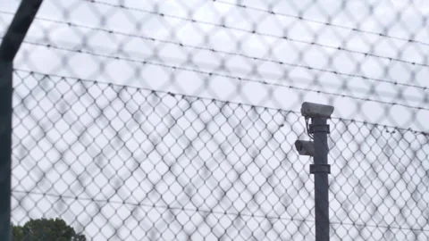 Tilt Up Security Cameras Behind Barbed Wire Fence Stock Footage 346009098