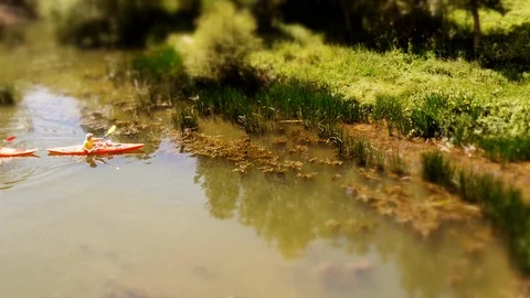 Tilt-Shift: Funny shot of Mini Kayak‘s leaving the river in La Rioja, Spain Stock Footage 97992734