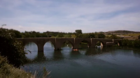 Tilt-Shift: Mini Kayak‘s paddle under bridge on river in La Rioja, Spain–wide Stock Footage 97992921