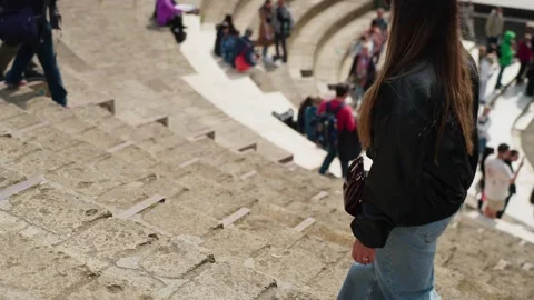 Tilt-shift style view of tourists moving through Pompeii amphitheater steps 库存影片 336214194