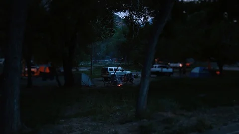 Tilt-shift Time-lapse of a group of people in a campsite at night Video stock 128837141