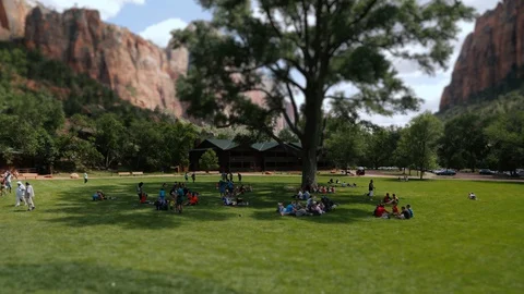 Tilt-shift time-lapse of a group of people in a field in Zion National Park Stock Footage 128840516