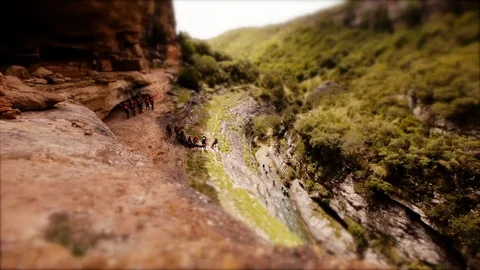 Tilt-shift: Tiny Canyoning group abseiling into a Canyon Stockbeeldmateriaal 98158001