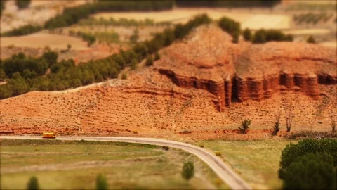 Tilt-shift: Tiny yellow truck passing by scenic road in Aragon, Spain Stock Footage 98167120