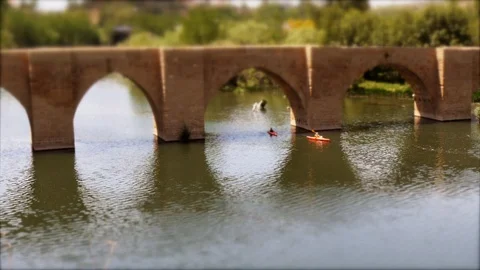 Tilt shift: Two Toy Kayak‘s paddle under historic bridge in La Rioja Stock Footage 97987684