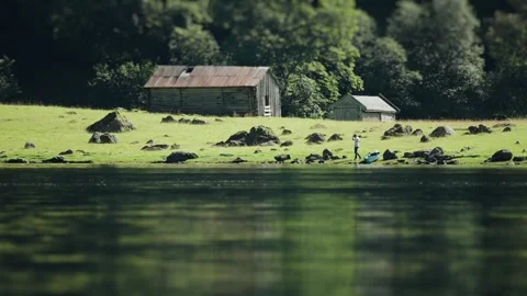 Tilt-shift video featuring two old wooden barns on the rocky coast of a Stock Footage 280227618