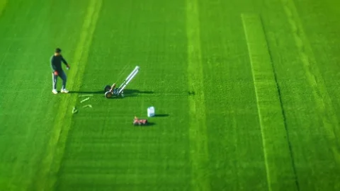 Tilt-Shift video of a team replacing a synthetic grass football (soccer) field Stock Footage 263576593