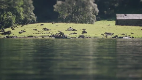 A tilt-shift video of two weathered wooden barns situated on the rocky Stock Footage 280448026