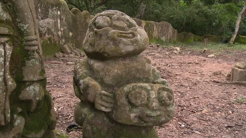 Tilt up from short squat statue to tall fertility statue Stock-Footage 86760788