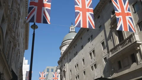 A tilt shot of British flags hanging in between buildings. Stock Footage 125945935
