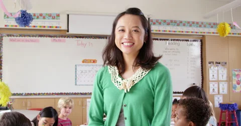 Tilt shot of female Asian school teacher in front of class Stock Footage