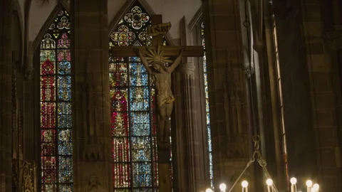 Tilt shot of a gothic cathedral interior with stained glass windows and crucifix Vídeo Stock 315366557