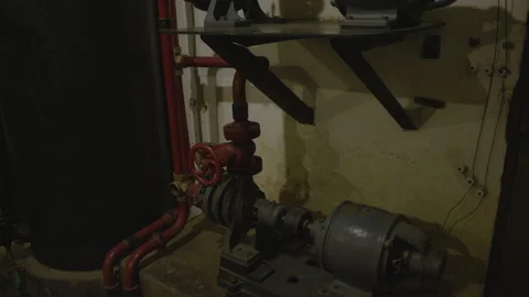 Tilt shot of a large, industrial pump system mounted on a wall Stock Footage 301034705