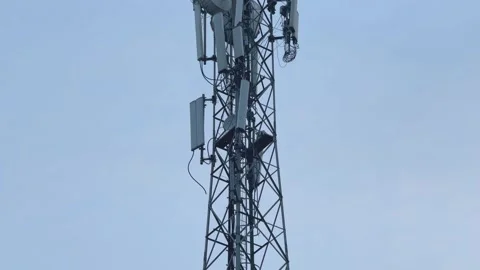 Tilt-Up Shot of Telecommunications Cell Tower with Multiple Cellular Antennas Stock Footage 346821334