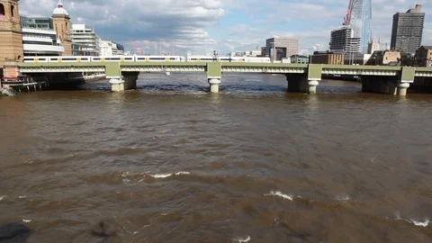 Tilt shot to a train passing on bridge, London Video stock 76384987