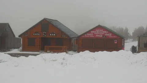 Tilt up shot on two closed coffee houses in a mountain village with snow. Stock Footage 121261540