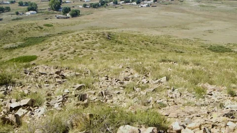 Tilt shot of view down into sunny valley from hilltop of remote village Stock Footage 122598409