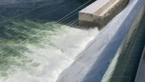 Tilt up side view of the Grand Coulee Dam spillway with water and power station 動画素材 245569563
