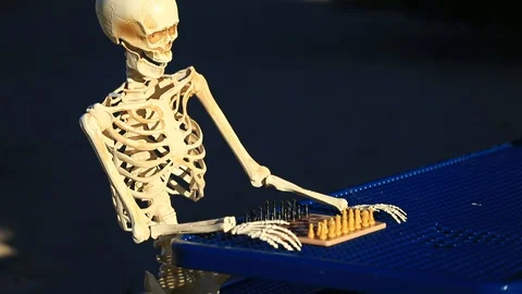 Tilt Up of Skeleton Playing Chess in the Park on a Picnic Table Stock Footage 97046099