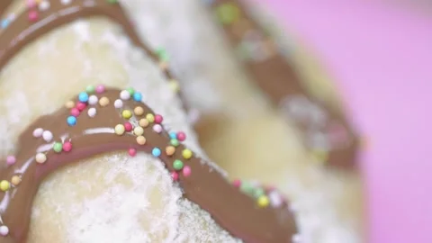 Tilt onto slow motion multicoloured candy onto donut Stock Footage 166863316