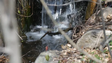Tilt up on small water fall Stock Footage 106062996