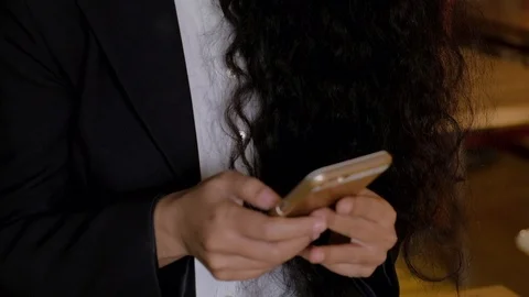 Tilt up from a smart phone mobile communication device with hands typing to the  Stock Footage 102422927