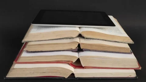 Tilt up to smart touch screen tablet on open retro hardbound books Stock Footage 68769273