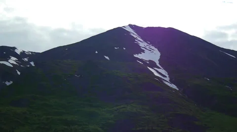 Tilt from Snowcapped Mountain Down to River with Green Banks Stock Footage 37435836