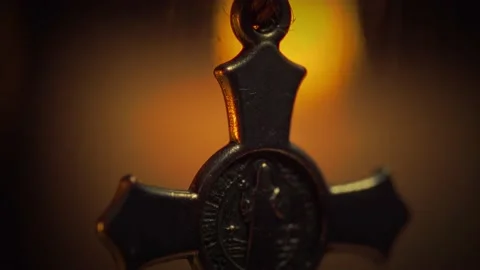 Tilt soft-focus shot of a Saint Benedict rosary and the candle Stock-Footage 163921364