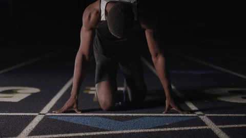 Tilt of a Sprinter in Starting Blocks Stock Footage 208743025