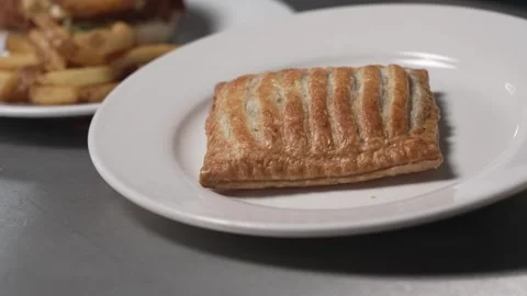 Tilt up to a steak bake pie from greggs, which is on a white plate. Stock Footage 280667490