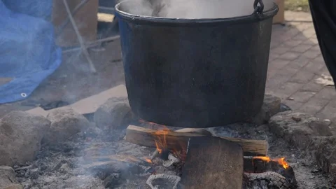 Tilt up on steaming cauldron slow motion outside 動画素材 121074034