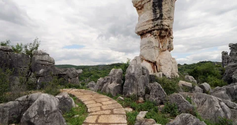 Tilt up from stone path to unique balancing karst rock of Shilin Stone Forest Stock Footage 329490215