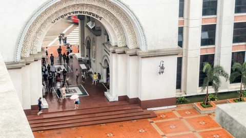 Tilt up Timelapse of People rush through gate in Assumption University rainy Stock-Footage 111164498