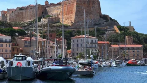 Tilt up view of bonifacio harbor with moored boats and castle Stock Footage 280715104