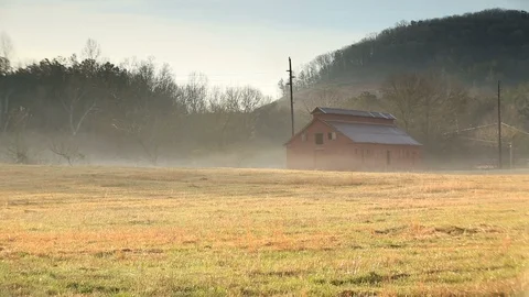 Tilt up view of red barn in field covered in fog. Stock Footage 85957825