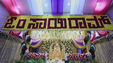 A tilt view of the Sai Ram or Sai Baba idol amidst floral decoration Vídeo Stock 234523225