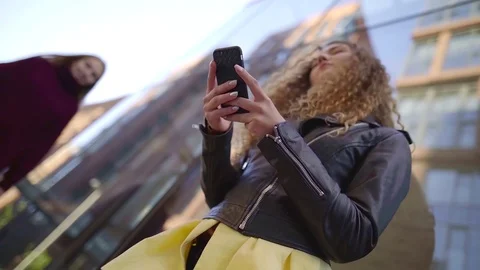 Tilt up view on two charming teens girls, reading messages on mobile phone on Video stock 97096535