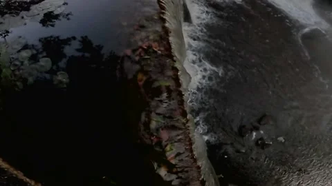 Tilt up of a water fall lake runoff fog and steam over the water early mornin Stock Footage 179212299